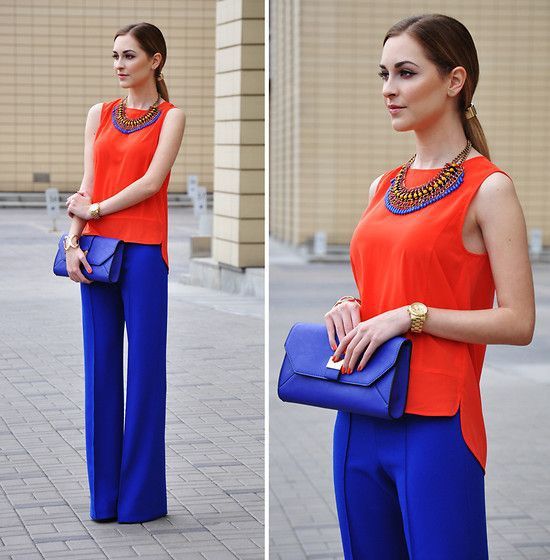 mulher loira de cabelo preso veste blusa laranja e calça azul - contraste alto entre as peças funciona melhor para quem tem contraste alto entre cabelo e pele